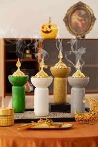 Dettaglio del bruciatore di incenso in resina in stile mediorientale con finitura e coperchio.