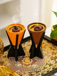Vue détaillée de brûle-encens coniques en résine avec effet bois et supports noirs en train de brûler.