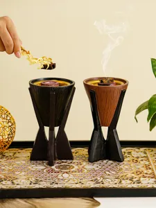 Vue détaillée du brûleur d'encens en résine avec design en bois et pinces pour brûler l'encens.