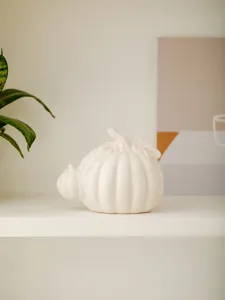 Modern minimalist white ceramic pumpkin figurine for autumn home decor desk ornament.