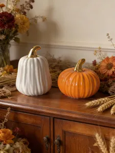 Ceramic pumpkin decoration detail, fine ribbed design with gold stem, cozy autumn home decor.
