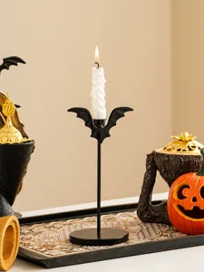 Vue détaillée du bougeoir chauve-souris en fer noir avec bougie blanche pour Halloween.