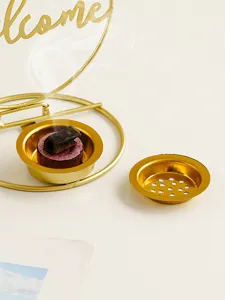 Close-up of gold iron incense burner holder accessory with hollow cup and elegant welcome design.