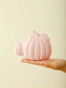 Ceramic pink pumpkin ornament detail view, modern home desktop and office decor.