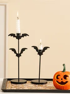 Gros plan de bougeoirs chauve-souris en fer noir avec des bougies pour déco d'Halloween.