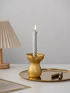 Gold resin flower candle holder detail view, minimalist art tabletop decor for home interior.