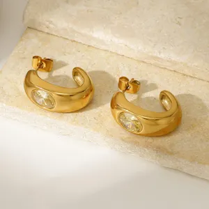Primer plano de pendientes de aro gruesos chapados en oro 18K con cristal amarillo.
