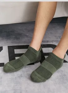 Primo piano di calzini sportivi corti verdi da uomo con mesh traspirante e comoda vestibilità.