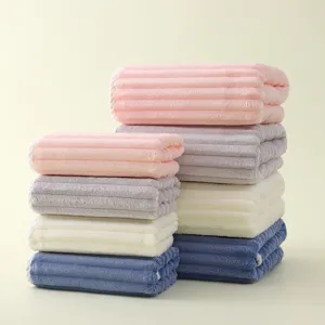 Ensemble de serviettes de bain rayées en polaire corail douce, pliées proprement.