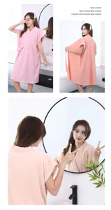 Vue détail de robe de bain gaufrée rose pour femme en scène de salle de bain douce.