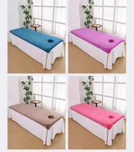 Close-up detail of thick microfiber spa bed covers with face hole in multiple colors.