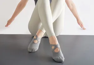 Chaussettes de yoga grises à brides croisées en détail pour le fitness et le pilates.