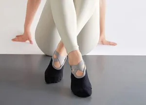 Gros plan des chaussettes de yoga antidérapantes avec des brides croisées pour sport.
