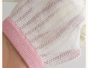 Close-up of white and pink mesh knit socks showing detailed breathable texture and design.
