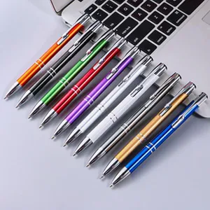 Metal retractable ballpoint pens detail view in various bright colors on keyboard surface.