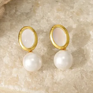 Detailed close-up of elegant gold-rimmed oval pearl drop earrings, showing delicate texture.