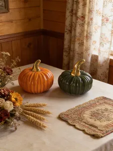 Ceramic pumpkin decor detail showing fine ribbed design and gold stem on table setup.