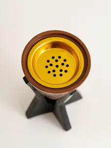 Vue détaillée du brûleur d'encens en résine avec bol métallique doré et support noir.