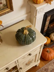 Detailed green ceramic pumpkin ornament featuring a shiny gold stem for home tabletop decor.