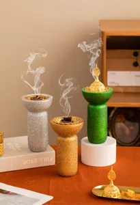 Bruciatore di incenso in resina stile Medio Oriente con finitura glitterata e coperchio dorato.