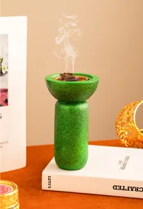 Vista dettagliata del bruciatore di incenso in resina con glitter verdi per aromaterapia.