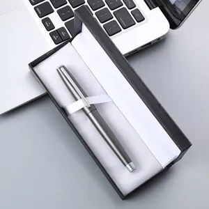 Close-up detail of a sleek metallic signature pen in an elegant black gift box on desk.