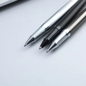 Close-up detail of three elegant metal rollerball pens with knurled grip design on desk.