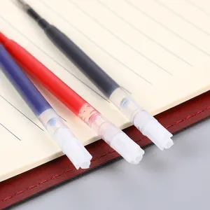 Vista detallada de recambios de bolígrafo de gel de 0.5mm negro, rojo y azul en cuaderno.