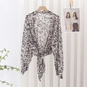 Detailed view of black and white printed sheer chiffon sun protection cardigan with front tie.