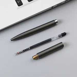 Minimalist metal gel pen with disassembled refill and spring on gray office background.