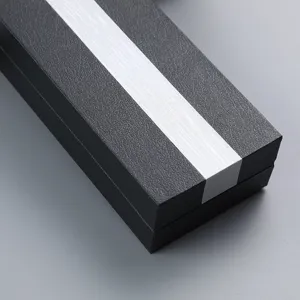 Primer plano detallado de una caja de regalo negra para bolígrafo con una raya plateada.