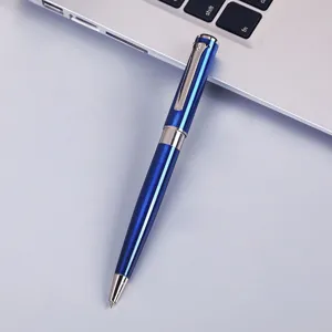 Detailed shot of a sleek blue metal ballpoint pen on a clean surface with laptop keyboard.