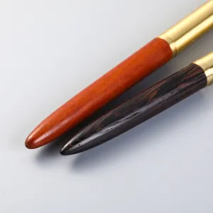 Holz und Messing Stift Detail Nahaufnahme mit feiner Holzmaserung und goldenen Akzenten.