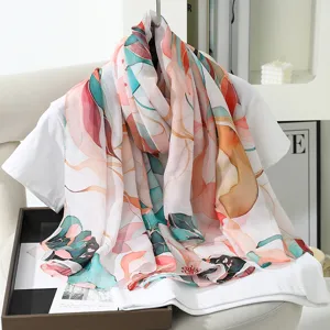 Detail shot of floral printed faux silk scarf draped on white top, elegant lifestyle presentation.