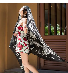 Close-up of a stylish black and white printed beach shawl worn outdoors, elegant summer style.