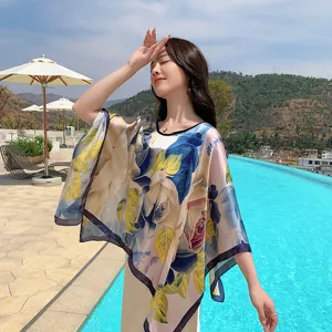Poolside view of women's floral print silk-feel sun protection cape shawl detail shot.