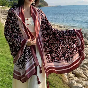 Vista dettagliata della sciarpa da donna con stampa leopardata e righe per le vacanze.