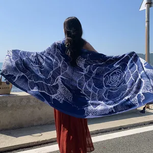 Dettaglio di scialle da spiaggia floreale blu boho, ideale per la protezione solare estiva.