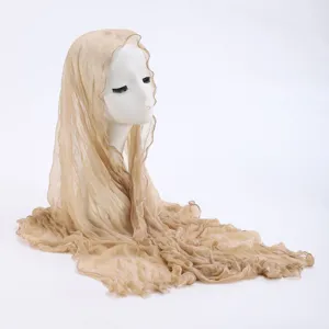 Detail shot of lightweight crinkled lace scarf, featuring sheer breathable texture and draped style.