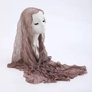Close-up detail of the lightweight taupe lace headscarf, showing the soft sheer texture and delicate drape.