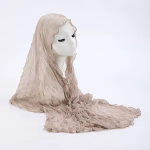 Detailed view of the lightweight crinkled sheer headscarf in light khaki, delicate fabric texture.