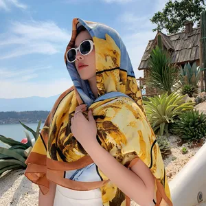 Outdoor detail shot of a floral art print square scarf shawl worn by model near scenic lake.