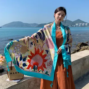 Sciarpa da spiaggia con stampa floreale e bordo blu, ideale per vacanze e protezione solare.