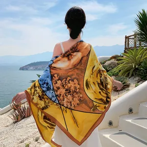 Detailed view of the artistic floral square scarf, elegant seaside backdrop, versatile accessory.