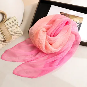 Gros plan détaillé du foulard plissé dégradé rose avec une texture douce et élégante.