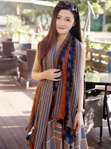 Detailed view of the ethnic print tassel cotton linen scarf worn by a model outdoors.