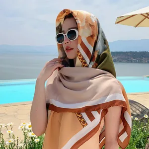 Detail shot of the stylish floral and chain pattern silk scarf worn by pool, elegant shawl.