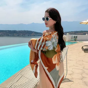 Detailed close-up of women floral print large square scarf shawl by outdoor pool scene.