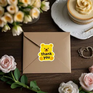 Gros plan détaillé du joli autocollant d'ours jaune sur l'enveloppe brune de détail.