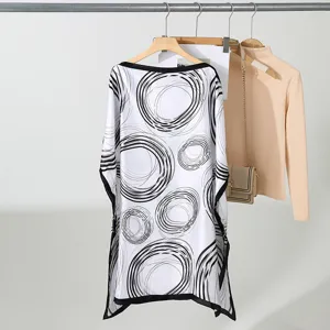 Detail van lichte zomerblouse met abstract cirkelprintpatroon, elegante wijde snit.